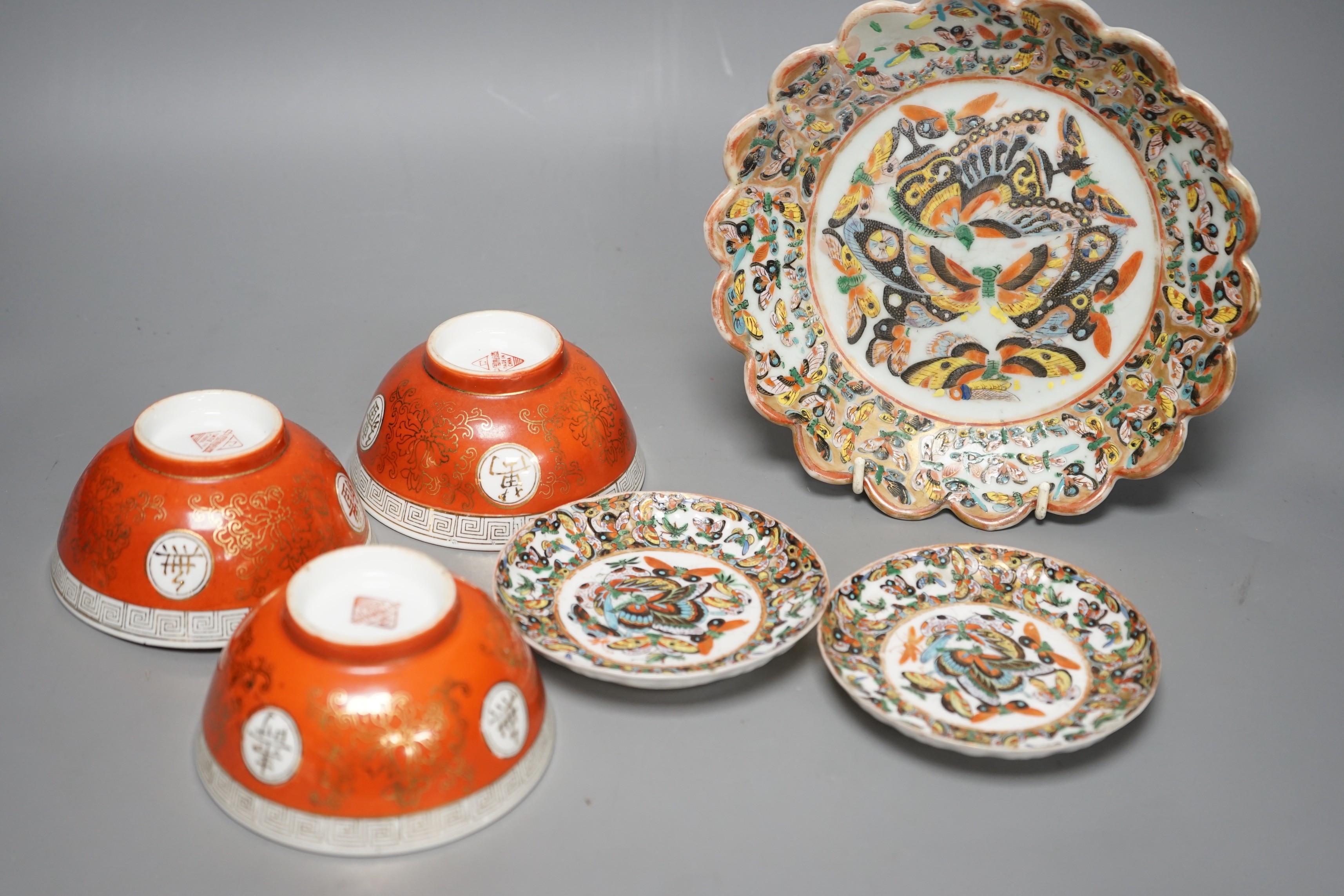 A Chinese 'thousand butterfly' dish and two saucers, early 20th century and three later Chinese coral round bowls, largest 20cm diameter